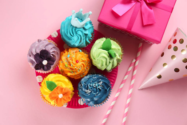 Deliziosi cupcake con scatola regalo su sfondo a colori
 - Foto, immagini