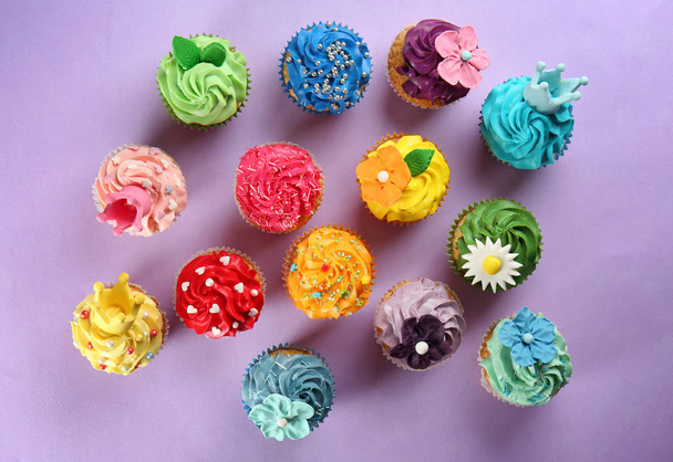 Deliciosos cupcakes no fundo da cor
 - Foto, Imagem