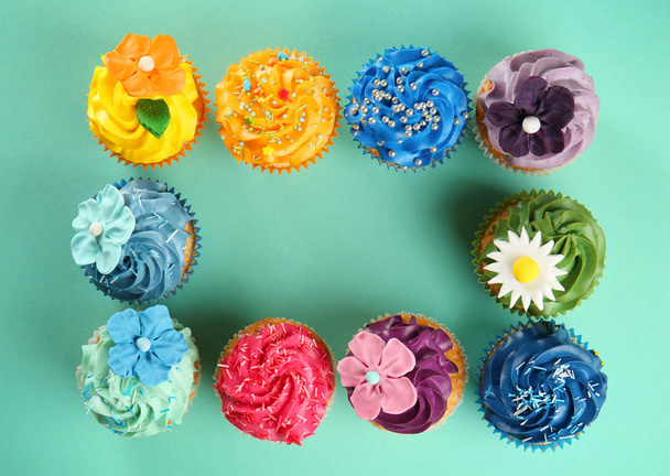Frame made of delicious cupcakes on color background - Photo, Image