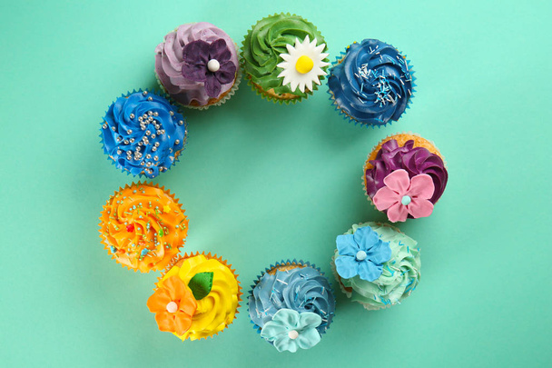 Cornice fatta di deliziosi cupcake su sfondo di colore
 - Foto, immagini