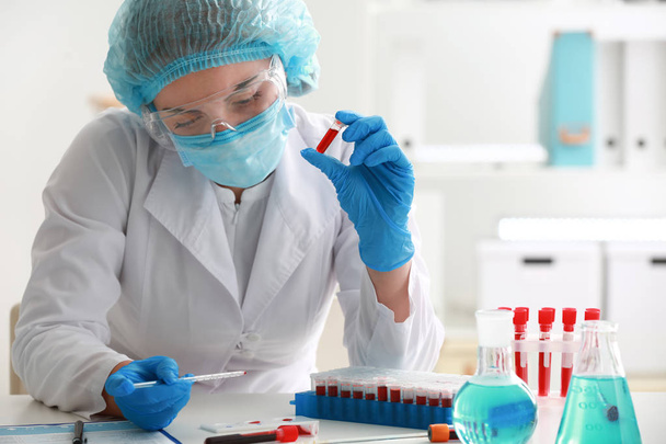 Femme travaillant avec un échantillon de sang en laboratoire
 - Photo, image