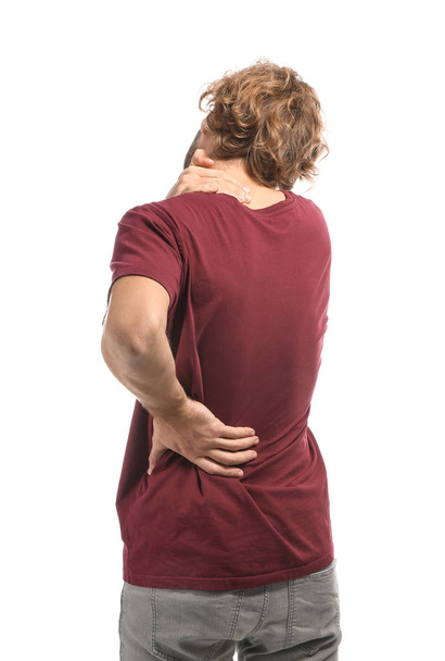 Fiatal férfi szenved hátfájás fehér háttér - Fotó, kép