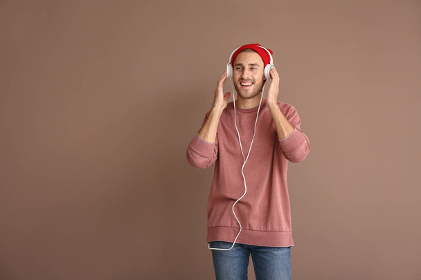 Молодий чоловік слухає музику на кольоровому фоні
 - Фото, зображення