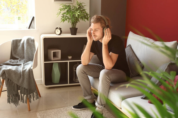 Genç adam evde müzik dinliyor. - Fotoğraf, Görsel