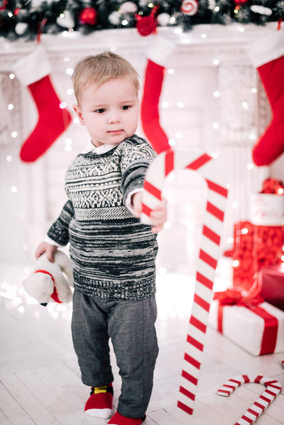 Karácsonyi portré egy fiatal fiú hangulatos hangulatot a kandalló és a karácsonyfa körül - Fotó, kép
