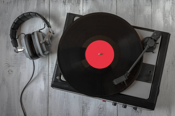 Old turntable for vinyl records and headphones lay on the table - Photo, Image