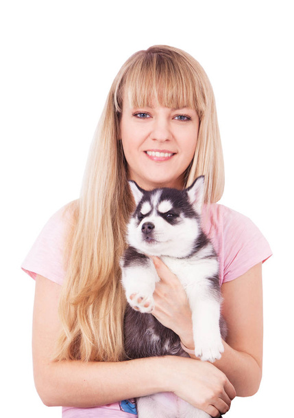Onnellisia naisia koiranpentunsa Huskyn kanssa studiossa. Eristetty valkoisella pohjalla
. - Valokuva, kuva