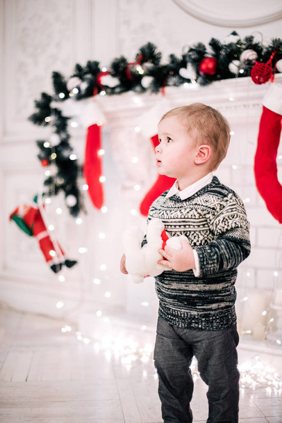 Weihnachtsporträt eines kleinen Jungen gemütliche Atmosphäre am Kamin und Weihnachtsbaum - Foto, Bild
