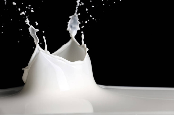 salpicadura de leche sobre fondo negro - Foto, imagen
