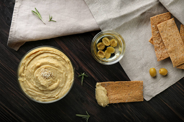 Ciotole con hummus e olive sul tavolo di legno
 - Foto, immagini