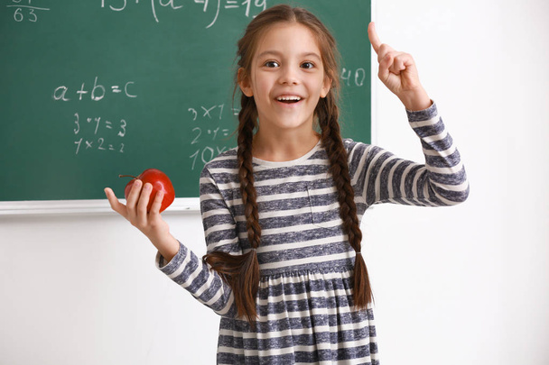 Cute girl with raised index finger in classroom - Фото, зображення