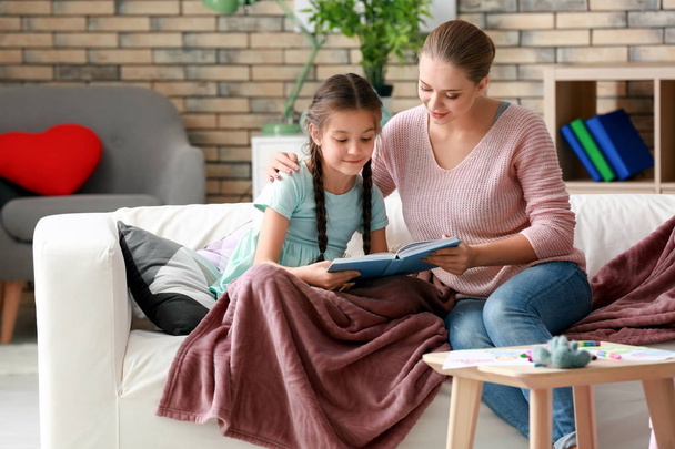 Милая девочка с мамой читает книгу дома
 - Фото, изображение