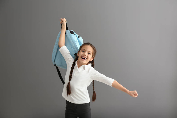 Happy girl with backpack on grey background - Foto, Imagem