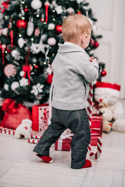 Karácsonyi portré egy fiatal fiú hangulatos hangulatot a kandalló és a karácsonyfa körül - Fotó, kép
