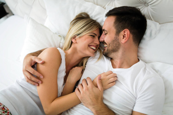 Young happy couple having having romantic times in bedroom - Fotó, kép