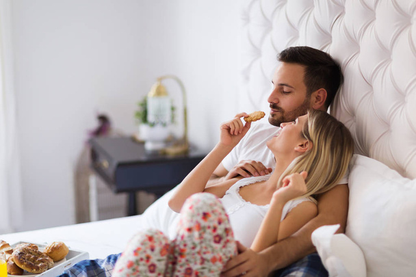 Young happy couple having having romantic times in bedroom - Photo, Image