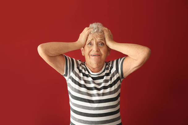 Retrato de mulher idosa depois de cometer erro no fundo de cor
 - Foto, Imagem