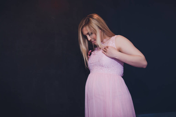 Niedbale ubrany atrakcyjna kobieta w ciąży stałego domu, patrząc aparatu i uśmiechając się, podczas gdy - Zdjęcie, obraz