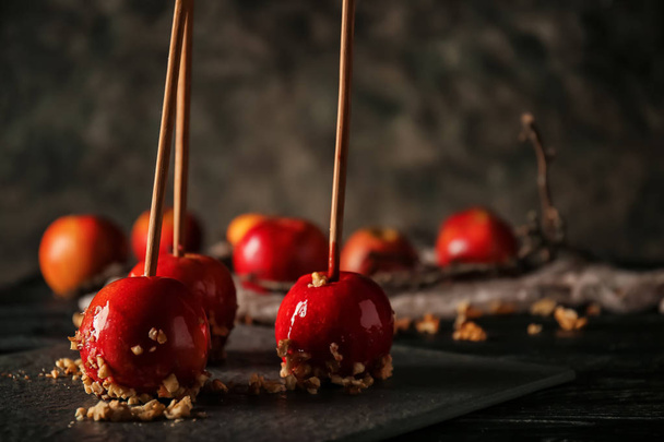 Delicious candy apples with nuts on slate plate - Photo, Image
