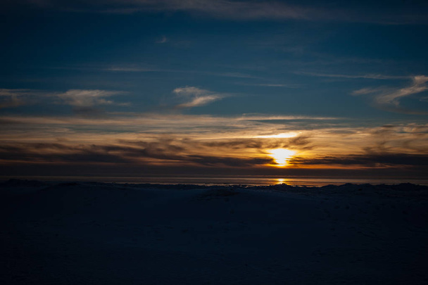 замороженная морская панорама пляжа зимой с большим количеством льда и снега поздним вечером
  - Фото, изображение