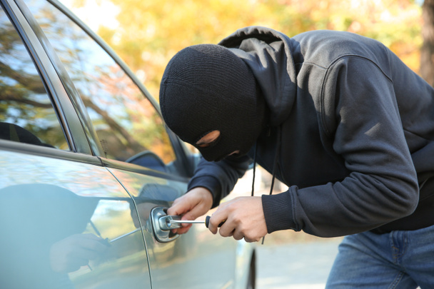 Mężczyzna złodziej próbuje otworzyć samochód - Zdjęcie, obraz