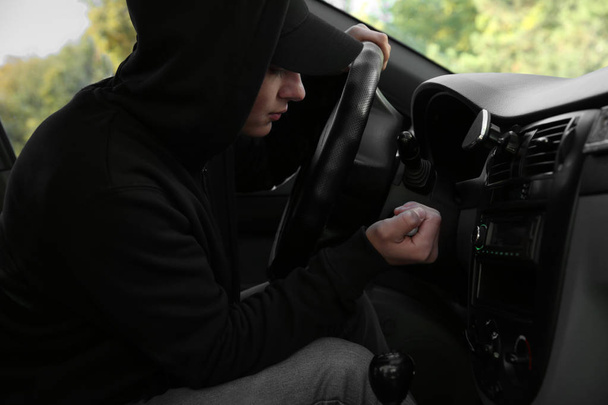 Αρσενικό κλέφτης κάθεται σε αυτοκίνητο - Φωτογραφία, εικόνα