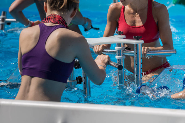 Mujer Doing Water Aeróbicos Aire libre en una piscina
. - Foto, Imagen