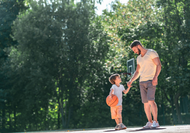 Father and son on the basketball court outdoors - Photo, Image