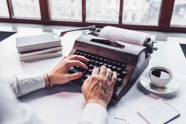 Young writer typing on a retro typewriter close-up - Photo, Image