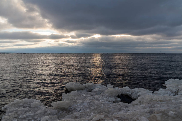 Befagyott tenger partján sok jég naplementekor - Fotó, kép