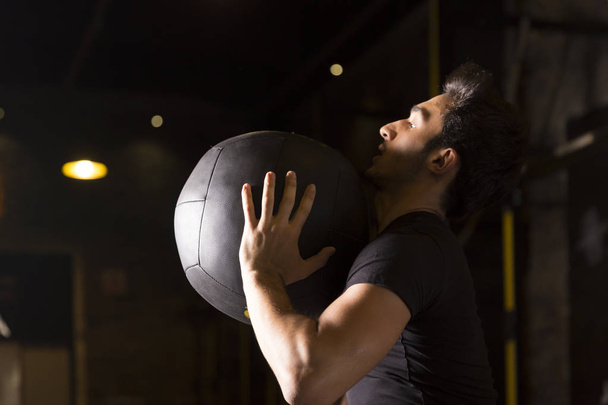 Спортсмен, який практикує настінні м'ячі з медичним м'ячем у спортзалі
. - Фото, зображення