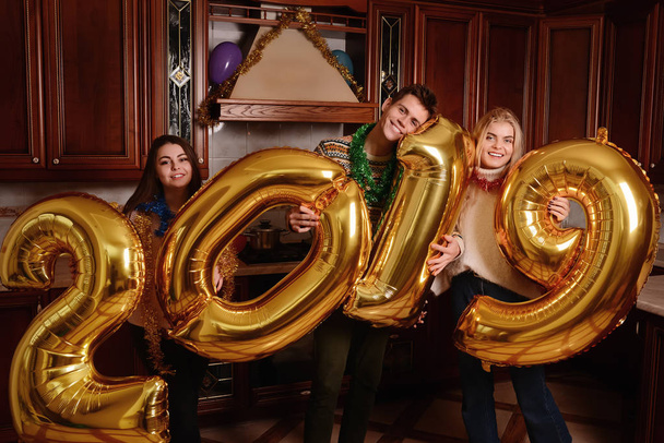 New 2019 Year is coming. Group of cheerful young people carrying gold colored numbers and have fun at the party. - Fotoğraf, Görsel