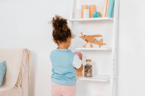 back view of cute african american child looking at toys on shelves - Φωτογραφία, εικόνα