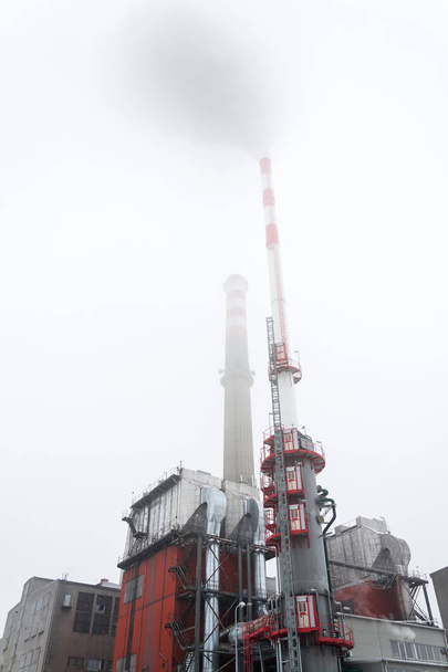 Vieja una nueva chimenea en la planta de calefacción cubierta de niebla, día nublado de invierno, vista de bajo ángulo, producción de energía, cambio climático y global, concepto de calentamiento
 - Foto, Imagen