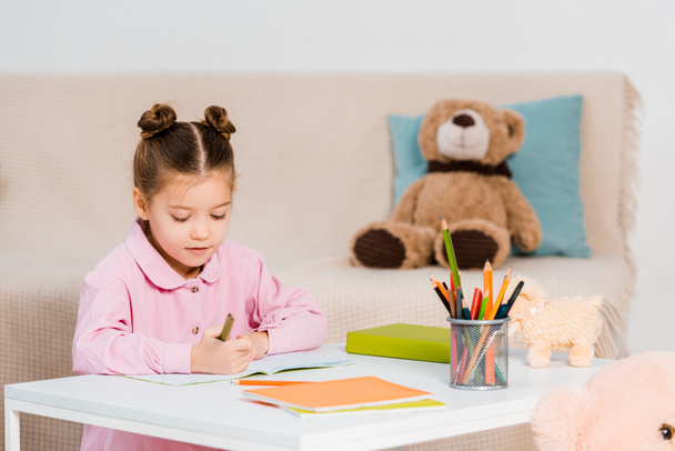 cute little child holding pencils and studying at home - Foto, imagen