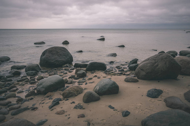 skalnaté pobřeží v Lotyšsku toku vody v moři velké kameny v pozdním podzimu. nudné barvy - vintage retro - Fotografie, Obrázek