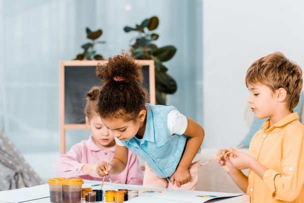 beautiful little multiracial children painting together  - Valokuva, kuva