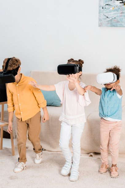 adorable multiethnic children playing in virtual reality headsets together   - Foto, afbeelding