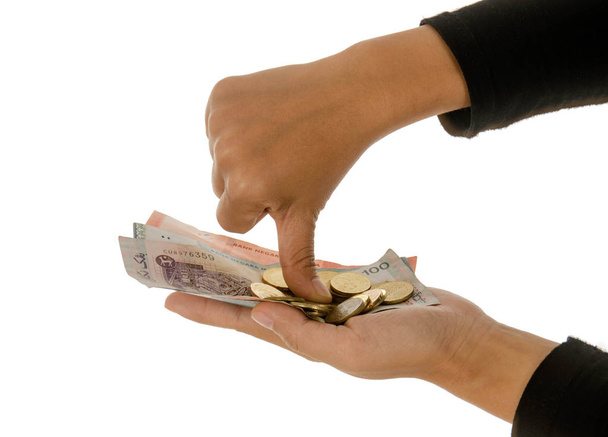 Een vrouwelijke hand aanhouden van geld tegen een witte achtergrond - Foto, afbeelding