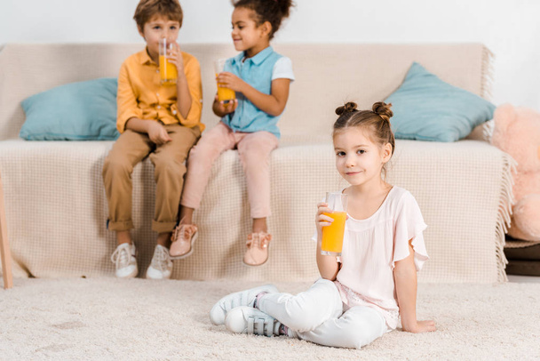 adoráveis crianças multiétnicas bebendo suco de laranja de óculos
 - Foto, Imagem