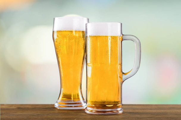 Cold beer in glasses on wooden table  - Photo, image
