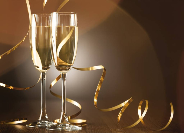 Glasses of champagne and curly golden ribbons - Foto, Imagen