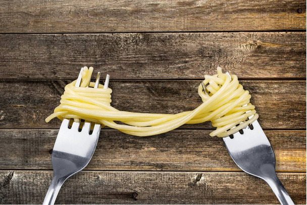 Forchette con deliziosi spaghetti sul tavolo di legno
 - Foto, immagini