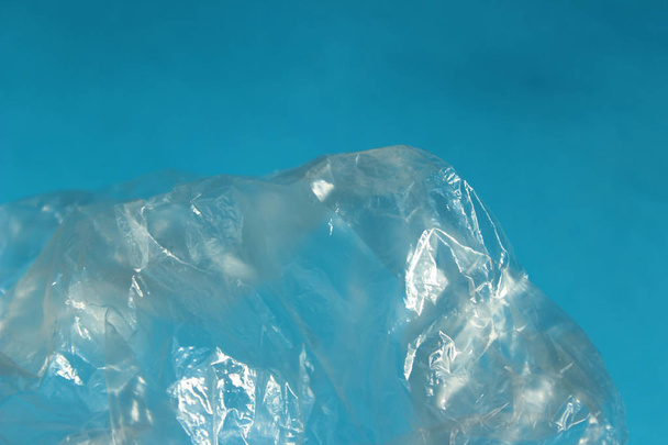 abstrakte Hintergrundtexturen. abgeschnittene Aufnahme einer Plastiktüte vor blauem Hintergrund. Umweltprobleme und Umweltverschmutzungskonzept.  - Foto, Bild