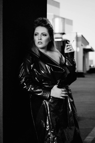 gorgeous young blond woman in leather coat smoking - Foto, immagini