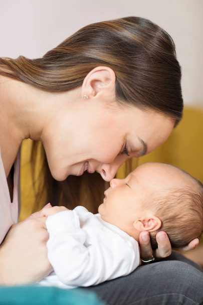Liefdevolle moeder zoontje knuffelen en aanraken van de neus - Foto, afbeelding