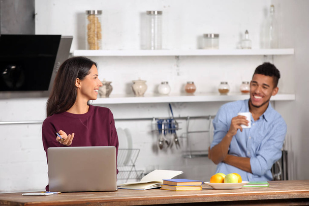 Young couple with laptop in kitchen - Photo, image