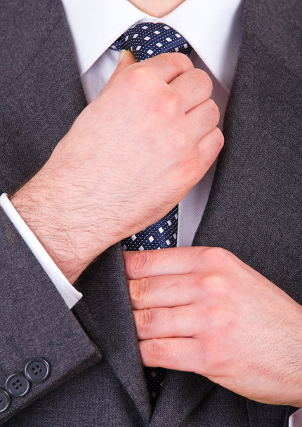 Деловой человек регулирует галстук
. - Фото, изображение