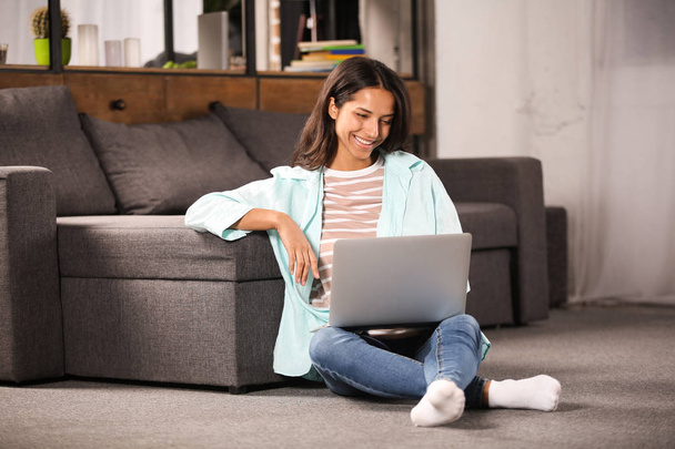 Nuori nainen työskentelee kannettavan tietokoneen kanssa kotona - Valokuva, kuva
