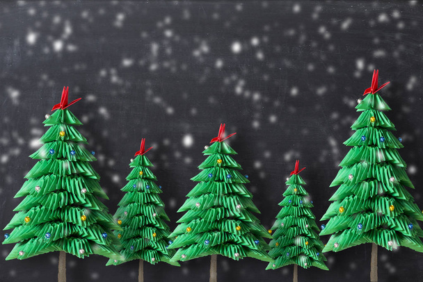 折り紙クリスマス ツリーは、暗い背景に緑の折り畳まれた紙を形成します。 - 写真・画像
